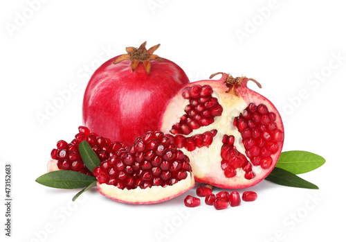 Tasty ripe pomegranates and leaves on white background