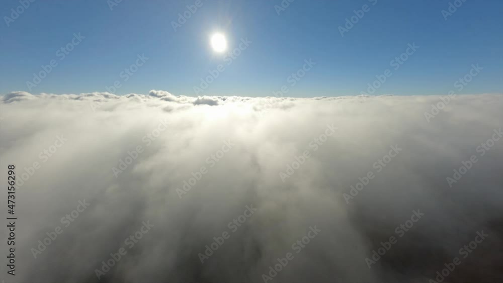 Aerial view sport FPV drone flying over fluffy cloud clear blue sky horizon with bright yellow sun. Above shot atmosphere cloudscape fluffy freedom heaven airplane trip natural sunlight. Epic beauty Aerial view sport FPV drone flying over fluffy cloud clear blue sky horizon with bright yellow sun. Above shot atmosphere cloudscape fluffy freedom heaven airplane trip natural sunlight. Epic beauty