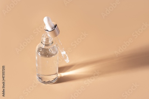 Glass vial with pipette filled with clear serum.