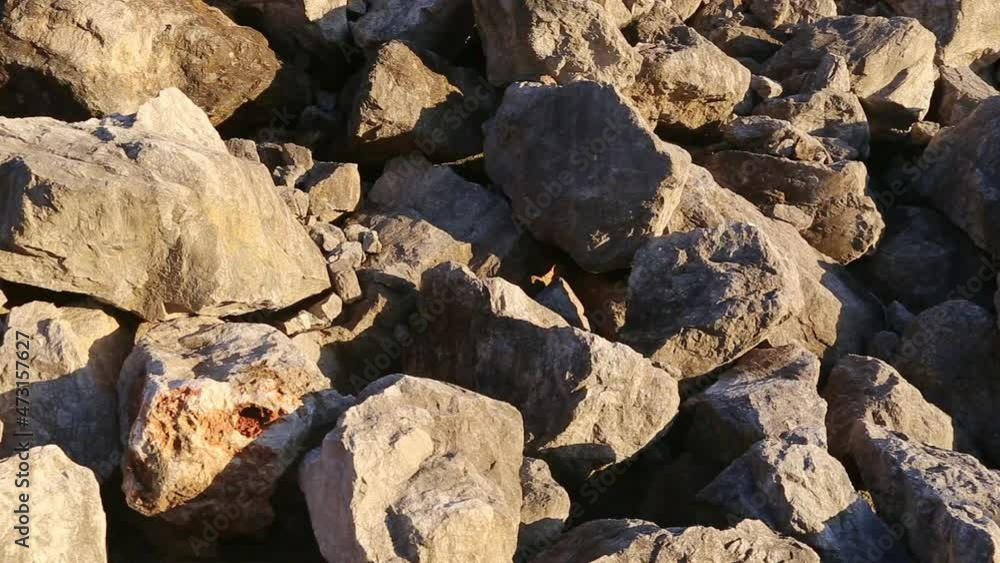 Stone and rock - close up. Heap of of crushed pieces used as natural building material. Texture of large broken boulders - pile of raw shattered aggregate from a quarry. Desolate mountain or hill. Stone and rock - close up. Heap of of crushed pieces used as natural building material. Texture of large broken boulders - pile of raw shattered aggregate from a quarry. Desolate mountain or hill.