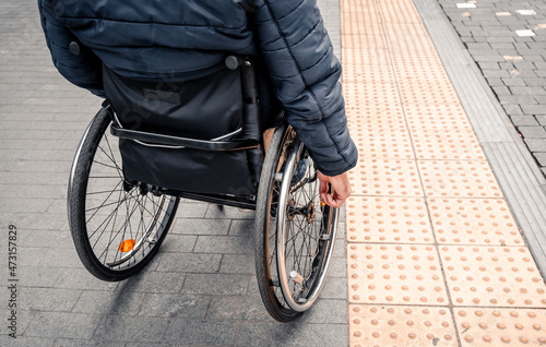 Person with a physical disability waiting for city transport with an accessible ramp.