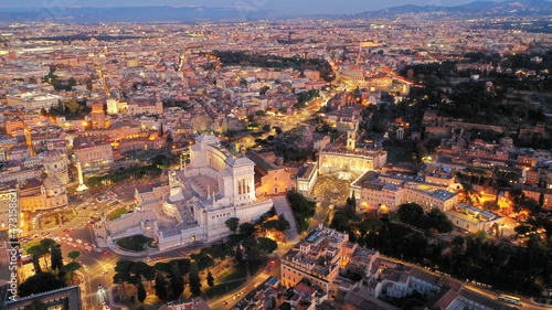 Aerial drone night shot of iconic monument in Venice square called Altar of the Fatherland at dusk with beautiful colours, Rome historic centre, Italy