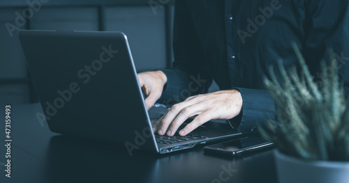 Businessman using a smartphone and notebook in a moddy office