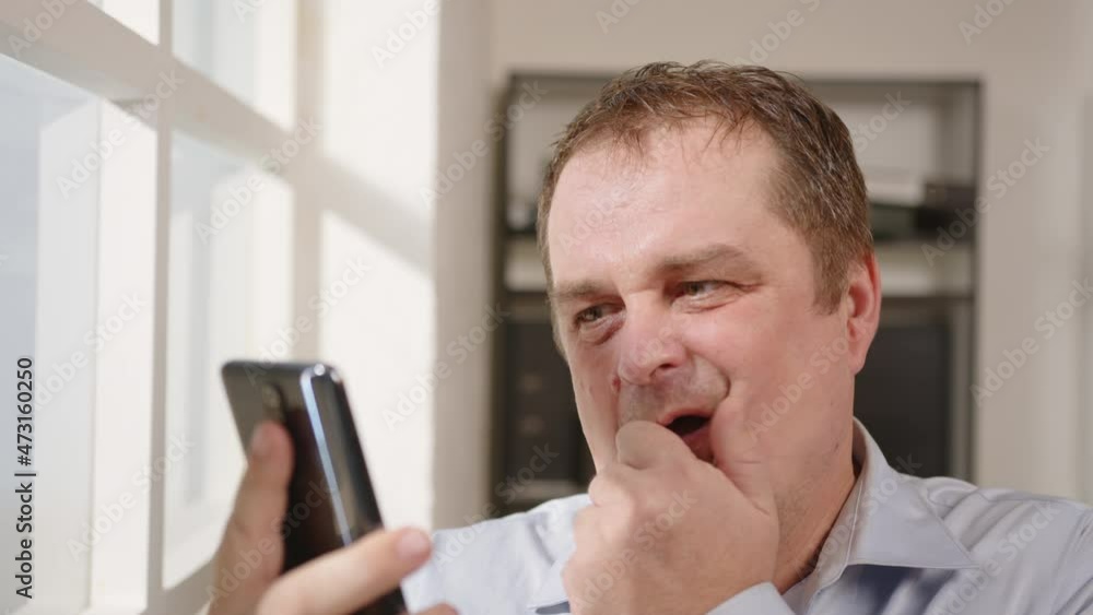 Portrait of businessman or stockbroker in tense state looking at smartphone screen and upset, business crash, collapse of stocks. Portrait of businessman or stockbroker in tense state looking at smartphone screen and upset, business crash, collapse of stocks.