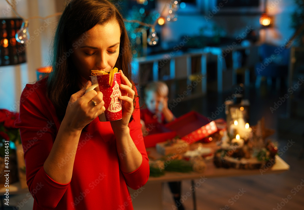 Pretty mother drinking the aromatic winter cup of a tea