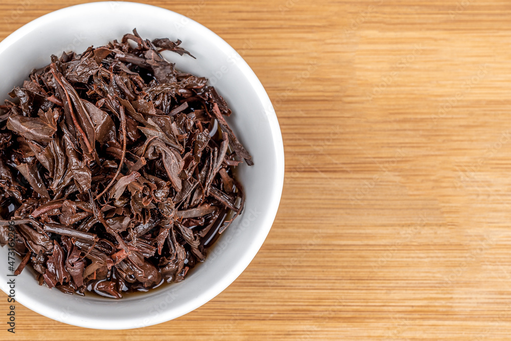 Close-up on a white bowl with used tea leaves.