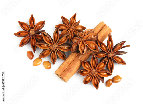 Dry anise stars and cinnamon stick on white background, top view