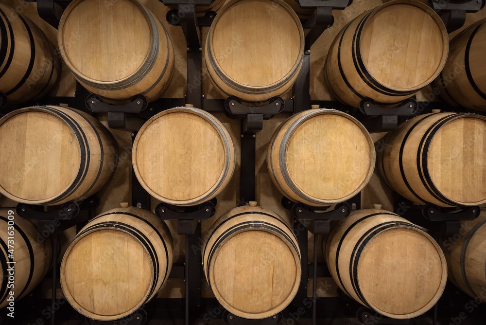 Barrels with red wine in winery vault, wine production background