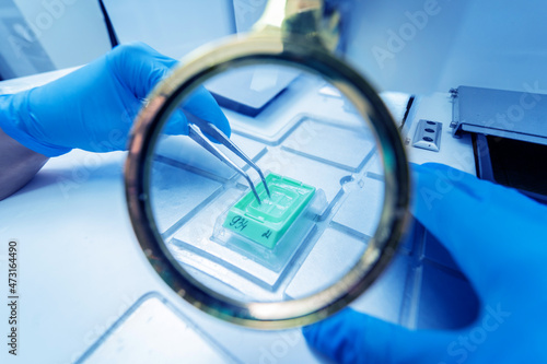 Laboratory assistant works at paraffin wax dispenser tissue embedding machine.