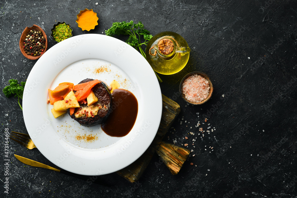 Veal steak baked with vegetables on a plate. Restaurant menu. European cuisine. Veal steak baked with vegetables on a plate. Restaurant menu. European cuisine.