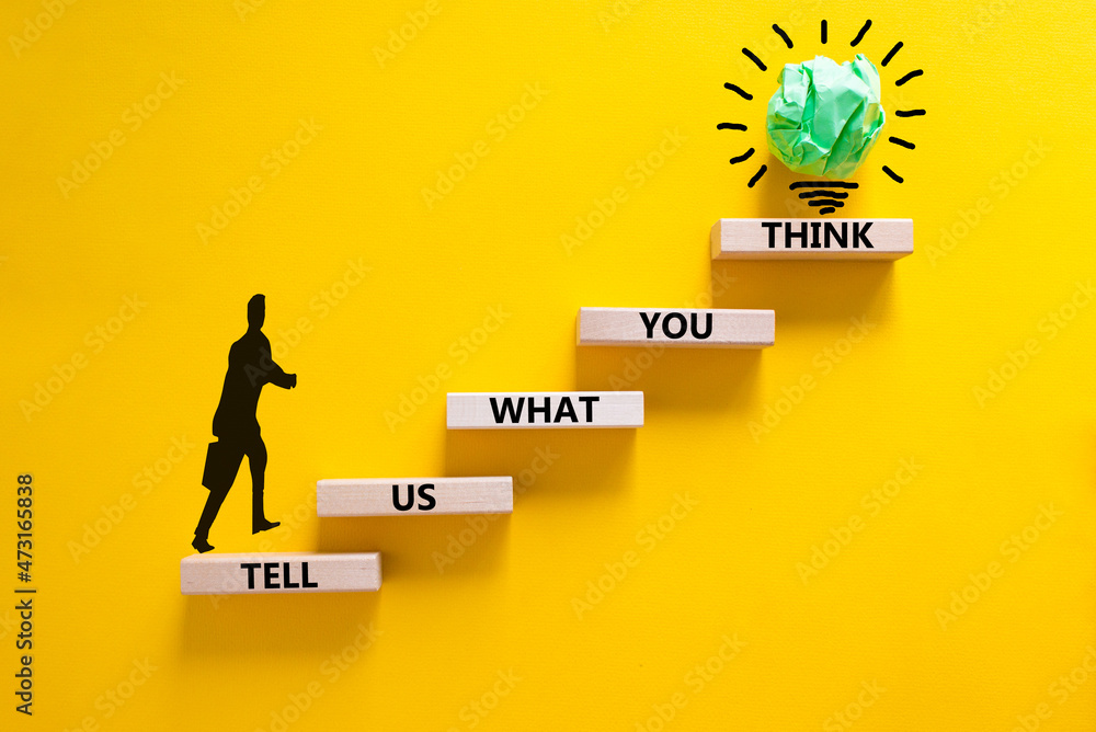 Symbol of building success and support foundation. Wooden blocks with words 'tell us what you think'. Beautiful yellow background, copy space. Businessman icon, light bulb. Business, support concept.