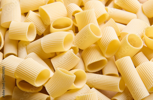 Pasta pattern. Close-up of a heap of uncooked whole wheat tortiglioni italian pasta. Food background