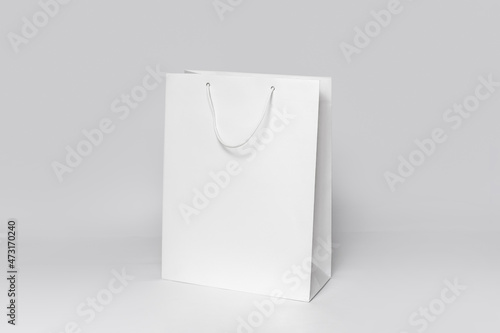 Mockup of white shopping bag isolated over white paper background. side view