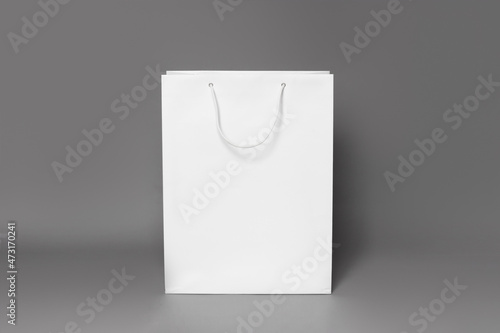 Mockup of white shopping bag isolated over dark grey paper background. straight view