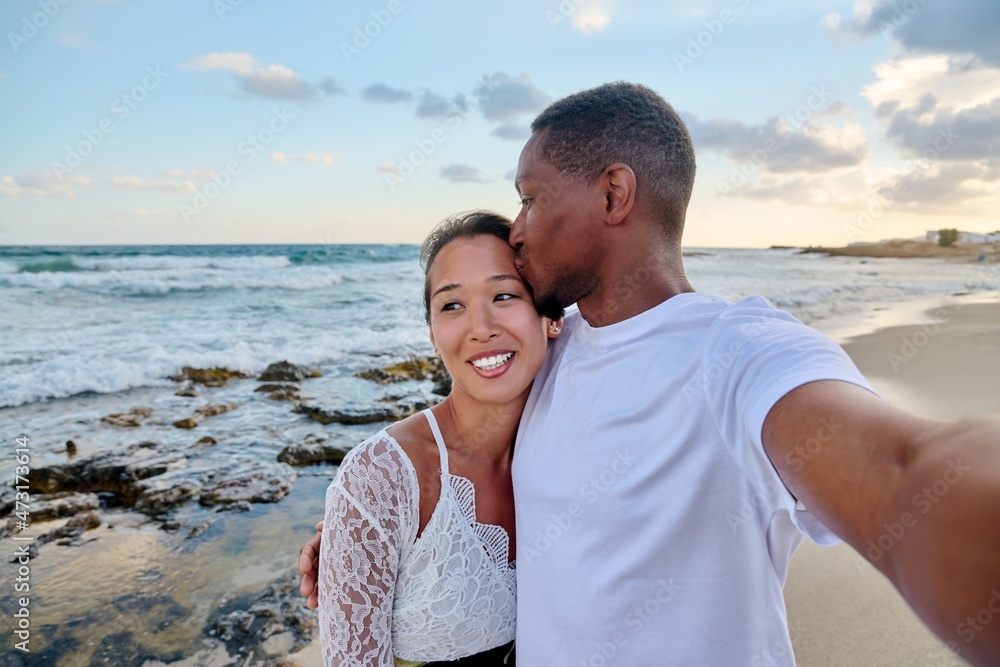 Happy couple in love kissing taking selfie together on smartphone, on beach Happy couple in love kissing taking selfie together on smartphone, on beach