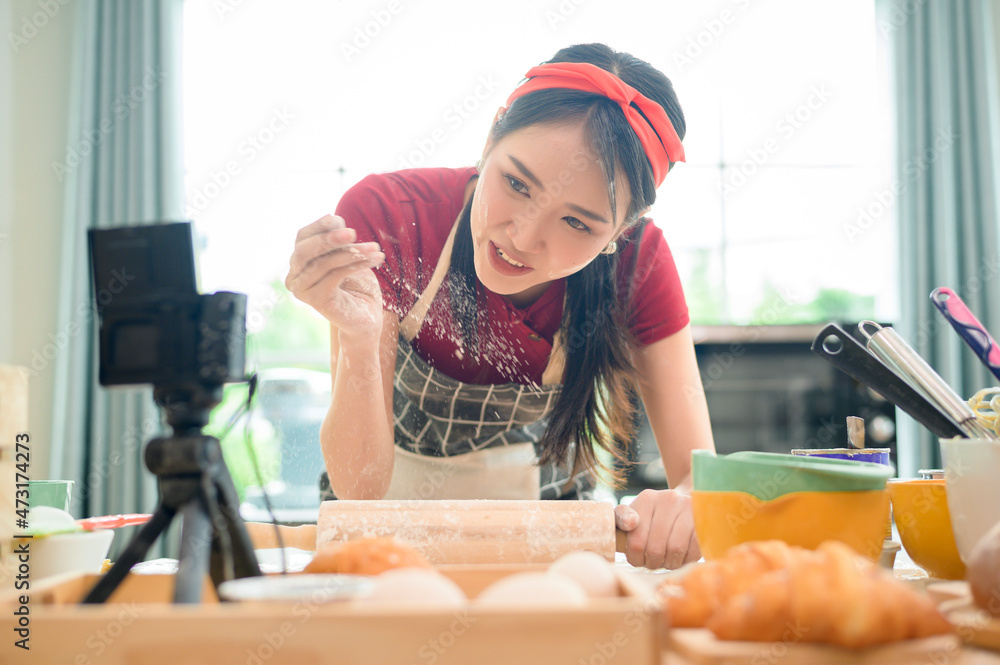 A Beautiful asian woman is making bakery , live streaming or recording video on social media in her house A Beautiful asian woman is making bakery , live streaming or recording video on social media in her house