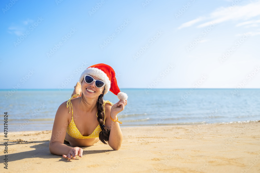 happy woman in santa hat and sunglasses lying on sand beach happy woman in santa hat and sunglasses lying on sand beach