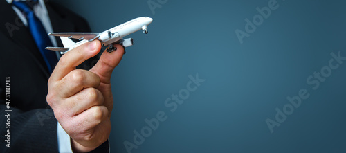 Businessman holding a airplane. Organization of flight traffic. Business and transport, air communication. Infrastructure for business development. Airline loyalty program. Tourism and travel.