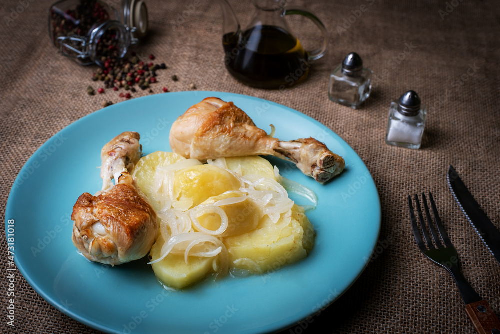 Lemon chicken thighs, garnished with potatoes and onion, cooked in the oven.