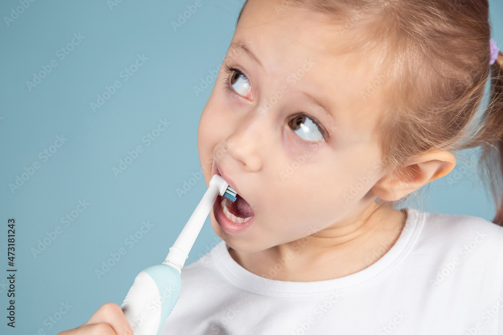 Portrait of cute little girl brushing teeth Standing Over blue Background Portrait of cute little girl brushing teeth Standing Over blue Background