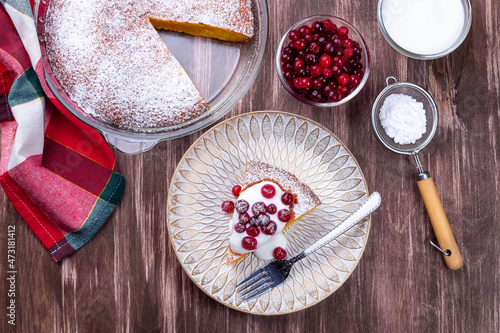 Piece of Swedish saffron Kladdkaka pie with white chocolate, whipping cream and cranberry horizontal photo