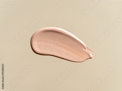 Liquid foundation isolated on beige nude background. Smear of foundation for face. Cosmetic smear of liquid foundation or bb-cream. Make-up color swatch