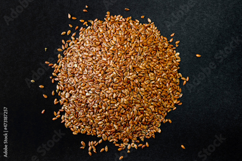 Flax grains on a black background. Healthy seeds. A handful of seeds.