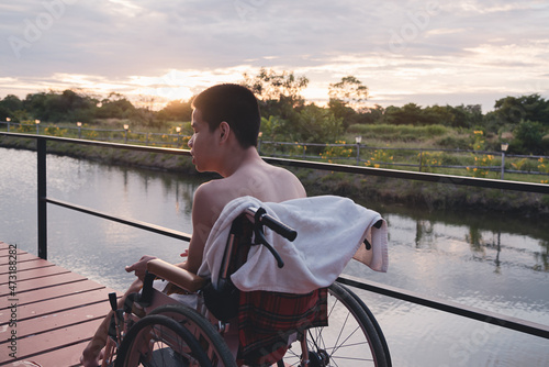 a young man with disability no shirt, He is going to swim on the lake in the outdoor vacation in summer at sunset, People leisure travel and good mental health concept.