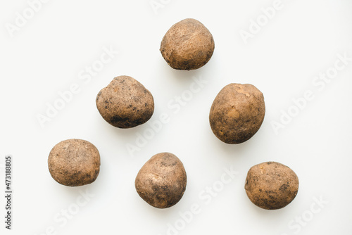 Potatoes on a white background. Dirty potatoes. 