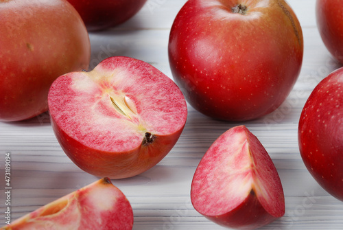 Red apples called Redlove are located on a wooden surface.