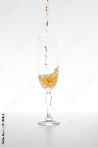 Champagne falling in glass on white background