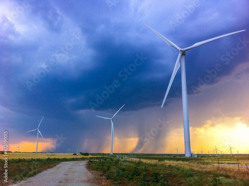 Wind turbines at sunset during approaching storm
