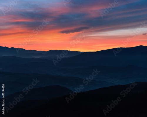 Amazing landscape in the mountains. View of mountains silhouettes and colorful sky at distance in twilight.