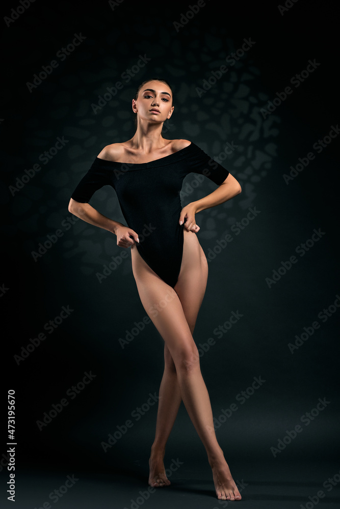 brunette woman with long legs in black bodysuit