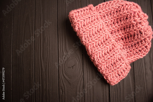 pink knitted hat for winter on a dark background