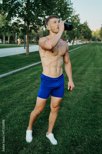 sports muscular man in the park healthy food fitness