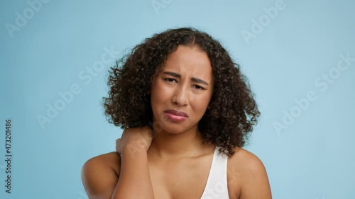 African American Lady Suffering From Nech Pain Over Blue Background photo
