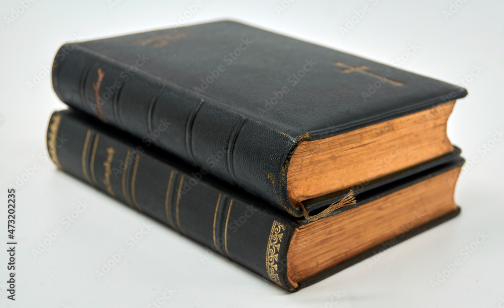 Two antique hymnals in a stack from 1910 and 1914. The edges are finished with real gold. Isolated on a white background. Two antique hymnals in a stack from 1910 and 1914. The edges are finished with real gold. Isolated on a white background.
