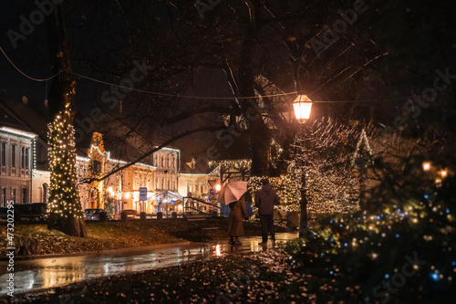 Street lamps shining light on the passing people during rainy  cold winter evening in the beautiful town of Samobor