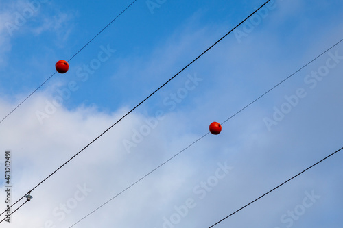 Electric wires with red plastic balls attached to them