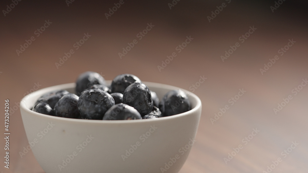 fresh washed blueberries poured into white bowl fresh washed blueberries poured into white bowl