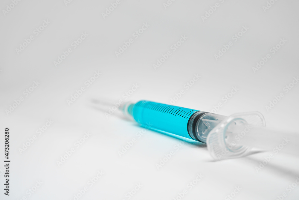 Syringe with blue liquid on white background Syringe with blue liquid on white background