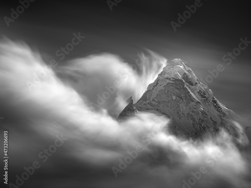Photography Black and white landscape with mountains peak and moving clouds in long exposure
