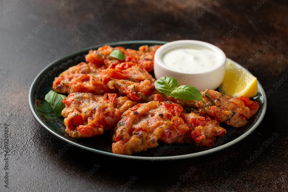 Fototapeta premium Greek tomato fritters, tomatokeftedes served with yogurt on plate.