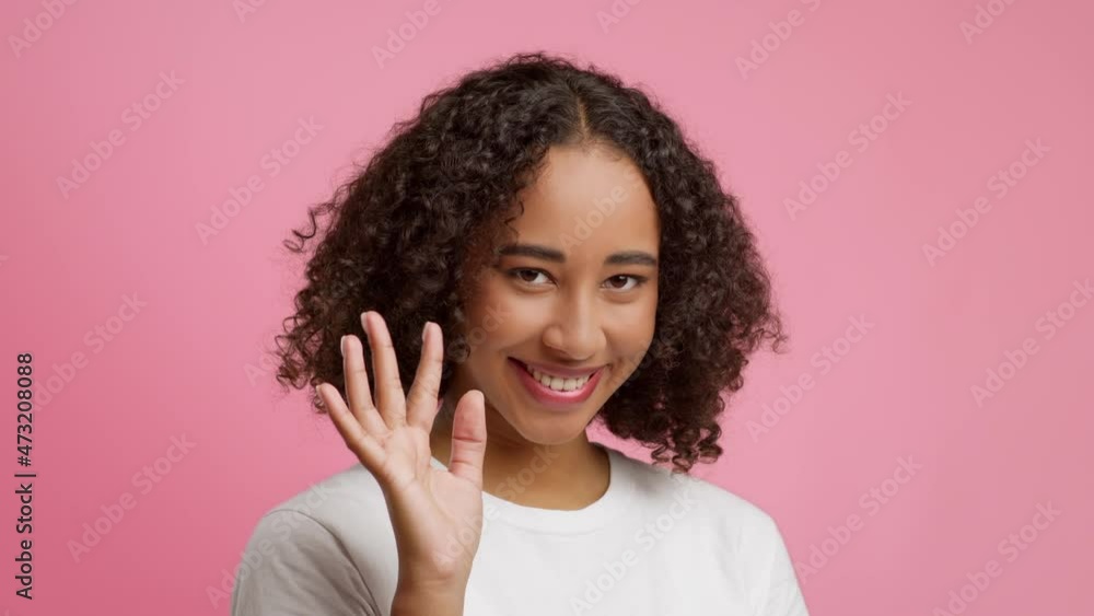 Playful African American Woman Waving Hello Smiling Over Pink Background Playful African American Woman Waving Hello Smiling Over Pink Background