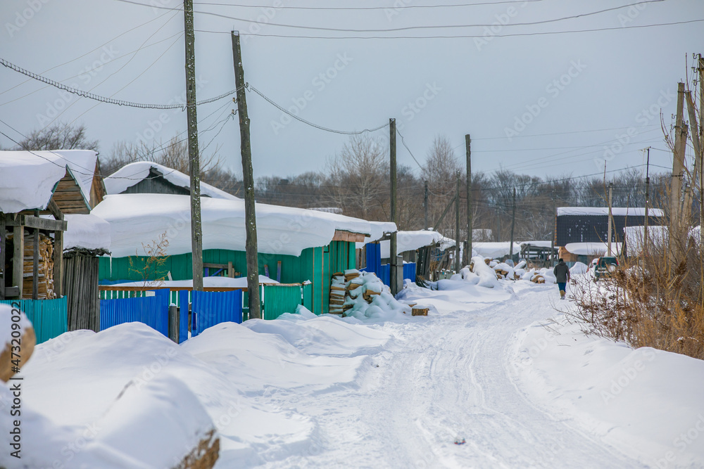The winter village of Krasny Yar of the small indigenous peoples of the north of Russia - the Udege. Street in the village in winter. Wooden Russian huts in a beautiful village. The winter village of Krasny Yar of the small indigenous peoples of the north of Russia - the Udege. Street in the village in winter. Wooden Russian huts in a beautiful village.