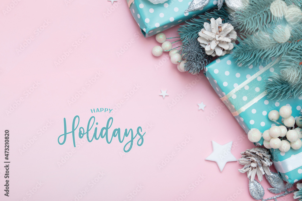 Happy holidays greeting card with christmas gifts, berries and pine flat lay on pink background with copy space Happy holidays greeting card with christmas gifts, berries and pine flat lay on pink background with copy space