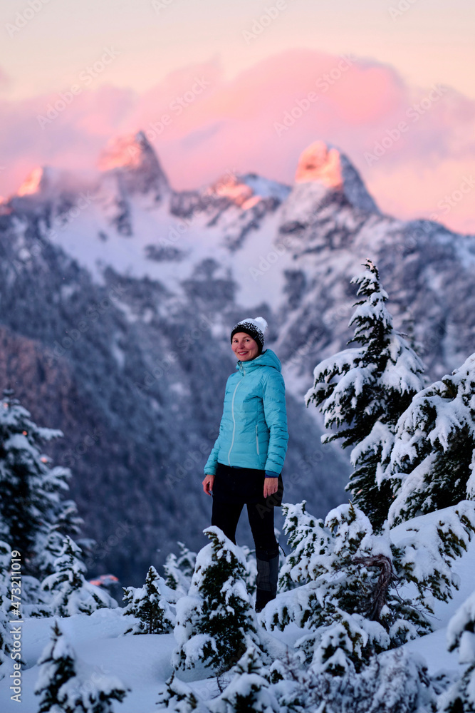 Middle age woman snowshoeing in mountain at sunset.  Cypress Mountain ski resort. Vancouver. British Columbia. Canada