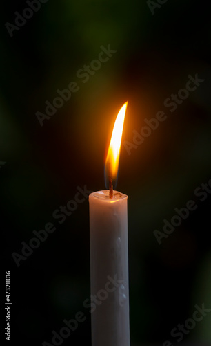 Candle light with dark bokeh background, in shallow focus