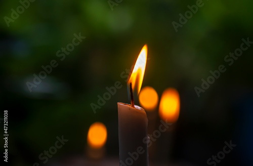 Candle light with dark bokeh background, in shallow focus